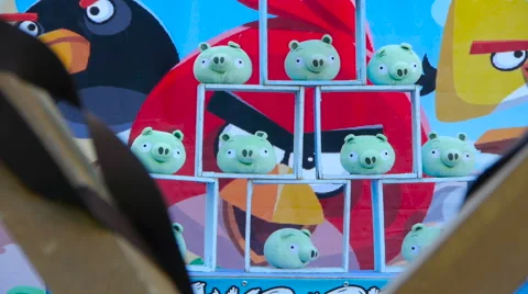Toy green pigs both inside and on the surface of a wooden structure Stock Footage 66878985