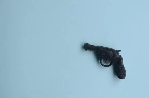 Toy gun on a blue background with empty space Stock Photos