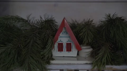A toy house in Christmas tree branches. Decoration for Christmas Stock Footage 239620193