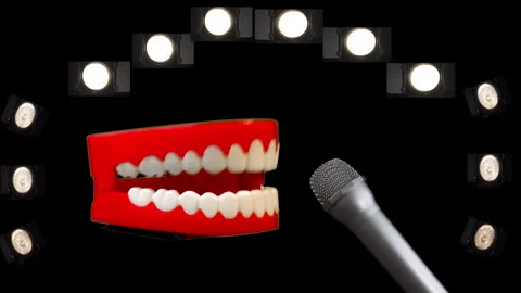 Toy joke chatty teeth with a microphone and spot lights. Stage performance. Stock Footage 240740387