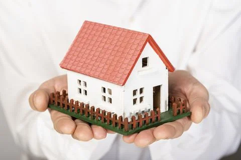 Toy model house held hands close up. High quality and resolution beautiful photo Stock Photos