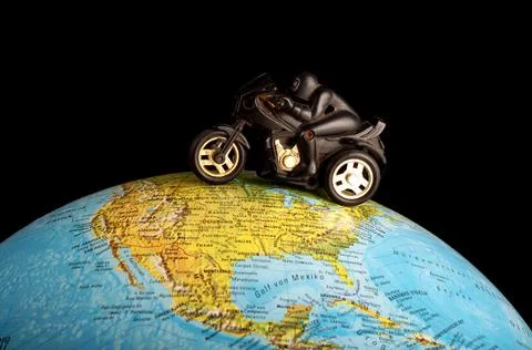 Toy motorcycle on globe Stock Photos