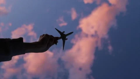 Toy plane in a hand, clouds background Stock Footage 135729908