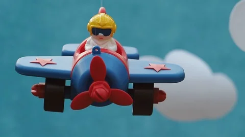 The toy plane with the pilot shakes on a grove. Paper clouds are near. Stock Footage 102796223