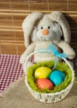 Toy rabbit with a basket of Easter eggs. Stock Photos