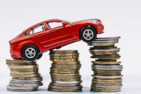Toy red car stack increasing coins against white background Beautiful photo 写真素材