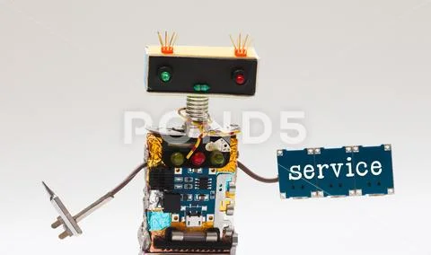 Toy robot handyman, screwdriver and microchip plate with text service. Fun Stock Photos