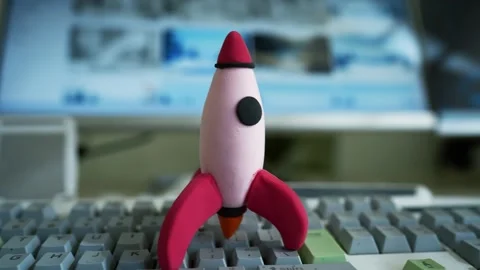 Toy Rocket on Computer Keyboard, A small toy rocket stands on a computer ke.. Stock Footage 304881496