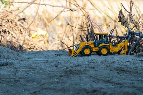 Toy scraper on mound of sand Stock Photos
