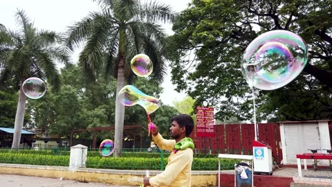A Toy seller creating transparent bubbles to attract children in Mysore Palace. Stock Footage 197363771