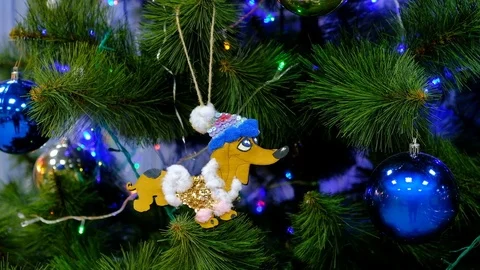 Toy in the shape of a dog on Christmas tree with balls and garlands. 스톡 동영상 85439697