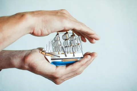 Toy ship in hands Stock Photos
