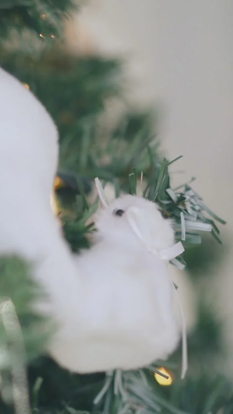 Toy squirrel hangs on Christmas tree with fairy lights Stock Footage 317624102
