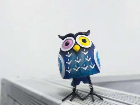A toy of a surprised blue owl with multi-colored eyes close-up Stock-Fotos