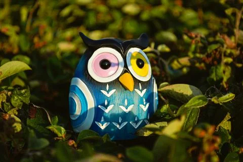 A toy of a surprised blue owl with multi-colored eyes close-up Stock-Fotos