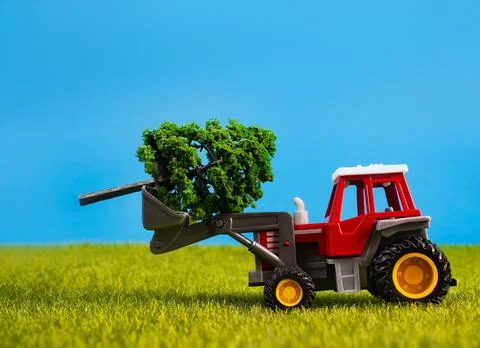 Toy tracktor with tree on grass. Stock Photos