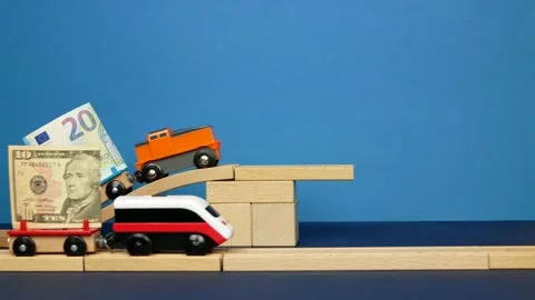 Toy train with banknote falls as symbol of falling euro currency against USD Stock Footage 144447200