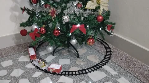 Toy train running on rails under a Christmas tree. With sound Stock Footage 225085607