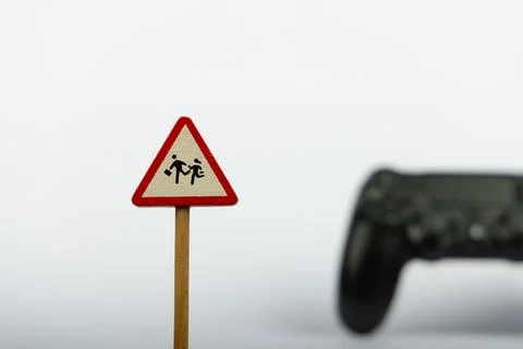 Toy Warning Sign with Game Controller on White Background Stock Photos
