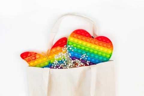 Toys Pop it, Simple Dimple rainbow color in a shopping bag on a white background Stock Photos
