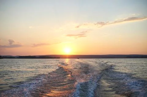 Trace from a boat on the river at sunset. Stock Photos