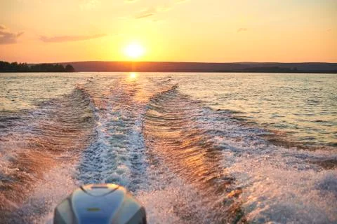 Trace from a boat on the river at sunset. Stock Photos