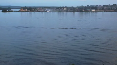 Trace from a boat on the water surface of the city pond in the pink sunset. Stock Footage 68457450