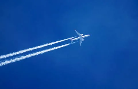 Trace of the high flying plane in the clear blue sky. Stock Photos