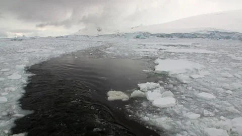 Trace waves on water from ship ice movement and snow coastline in Argentina. Stock Footage