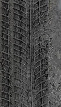 Traces of car tire tread in the ground. Pattern. Dark abstract background. Im Stock Photos