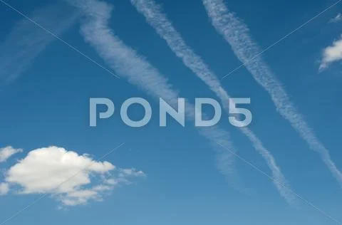 Traces of planes and clouds in the sky Stock Photos