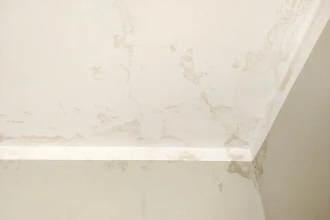 Traces of water on the ceiling and wall from the flood. The roof is leaking.  Stock Photos