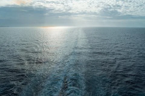 Traces of waves and foam on the surface of the blue sea with a copy of the sp Foto stock