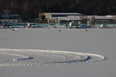 Traces of the wheels in the snow drift on the background of aircraft. track f Stock Photos