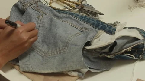 Tracing a star shape pattern on an old recycled denim short to make a DIY Video stock 297657295