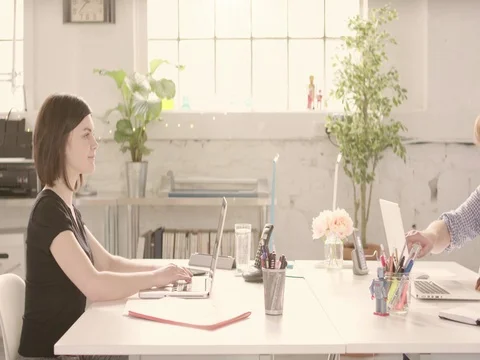 Track across table in casual sunny startup office with young happy adults Stock Footage 72882004