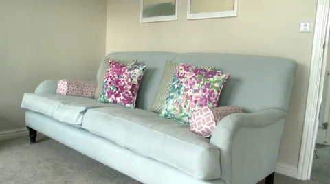 Track and pan from sofa to paintings in living room Stock Footage 35754332