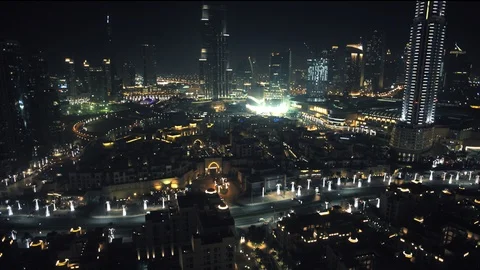Track back at 100m over Downtown Dubai while panning up to reveal Burj Khalifa Stock Footage 98984398
