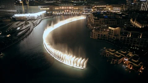 Track back while descending from 80m to 40m, past Dubai Fountain over Palace Stock Footage 98969792