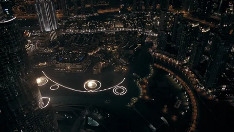 Track forward at 400m from behind Burj Khalifa, looking down at fountain, night. Stock Footage 98974492