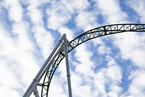 Track to green roller coaster with clouds in the sky Stock Photos