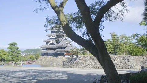 Track Left From Trees to Reveal Distant Side View Matsumoto Castle Moat Japan Vidéo 127619201