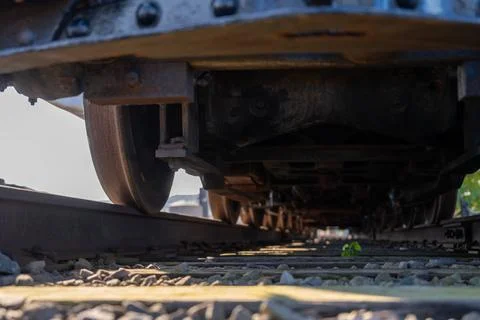 Track level view of a railroad train and wheels as they cross over Stock Photos