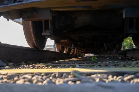 Track level view of a railroad train and wheels as they cross over Stock Photos