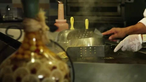 A Track right of chef mixing noodle shrimp and vegetable dish on flat top Stock Footage 155449209