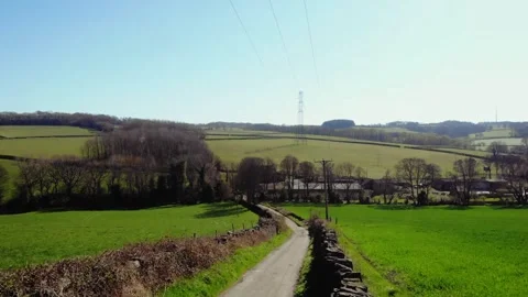 Track road through green fields in British countryside drone aerial Vídeo Stock 321294426