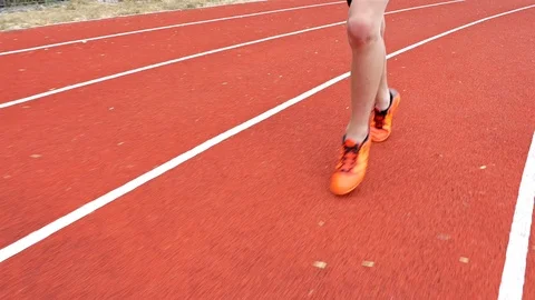 Track runner boy teenager legs running in a stadium, steadicam shot Stock Footage
