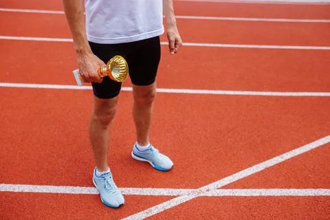 A track runner is standing at the starting line, getting ready for a quick .. Stock Photos