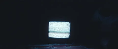 Track-in shot for an old TV set on the ground and static noise flickers Stock Footage 213073402