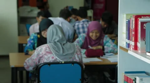Track Shot from Out Of Focus Students to Books on Library Shelf Stock Footage 49387878